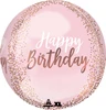 A pink balloon that has rose gold dots on the borders and says happy birthday in white and rose gold lettering